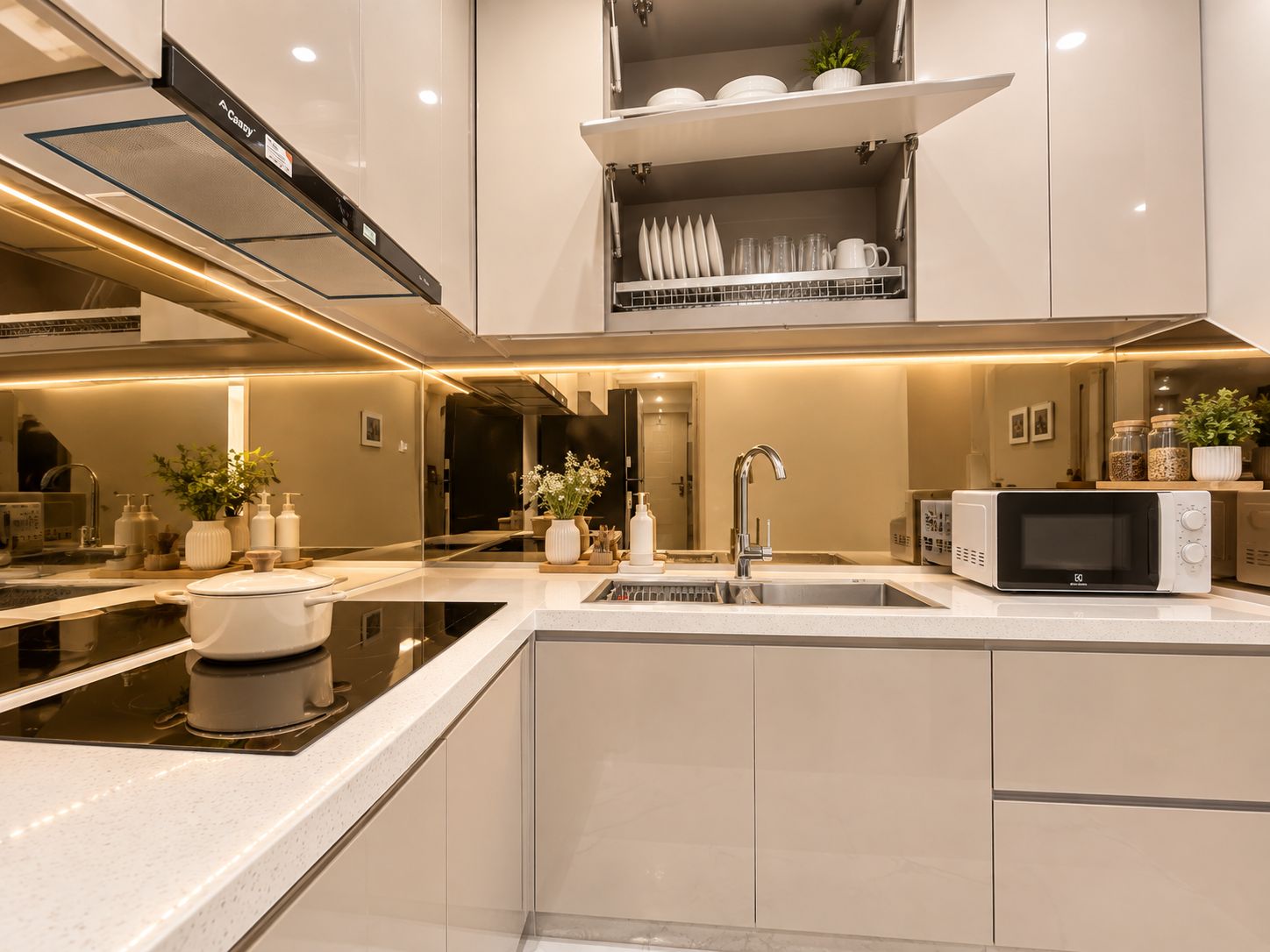 A modern kitchen with a built-in microwave, a sink, and a stove.