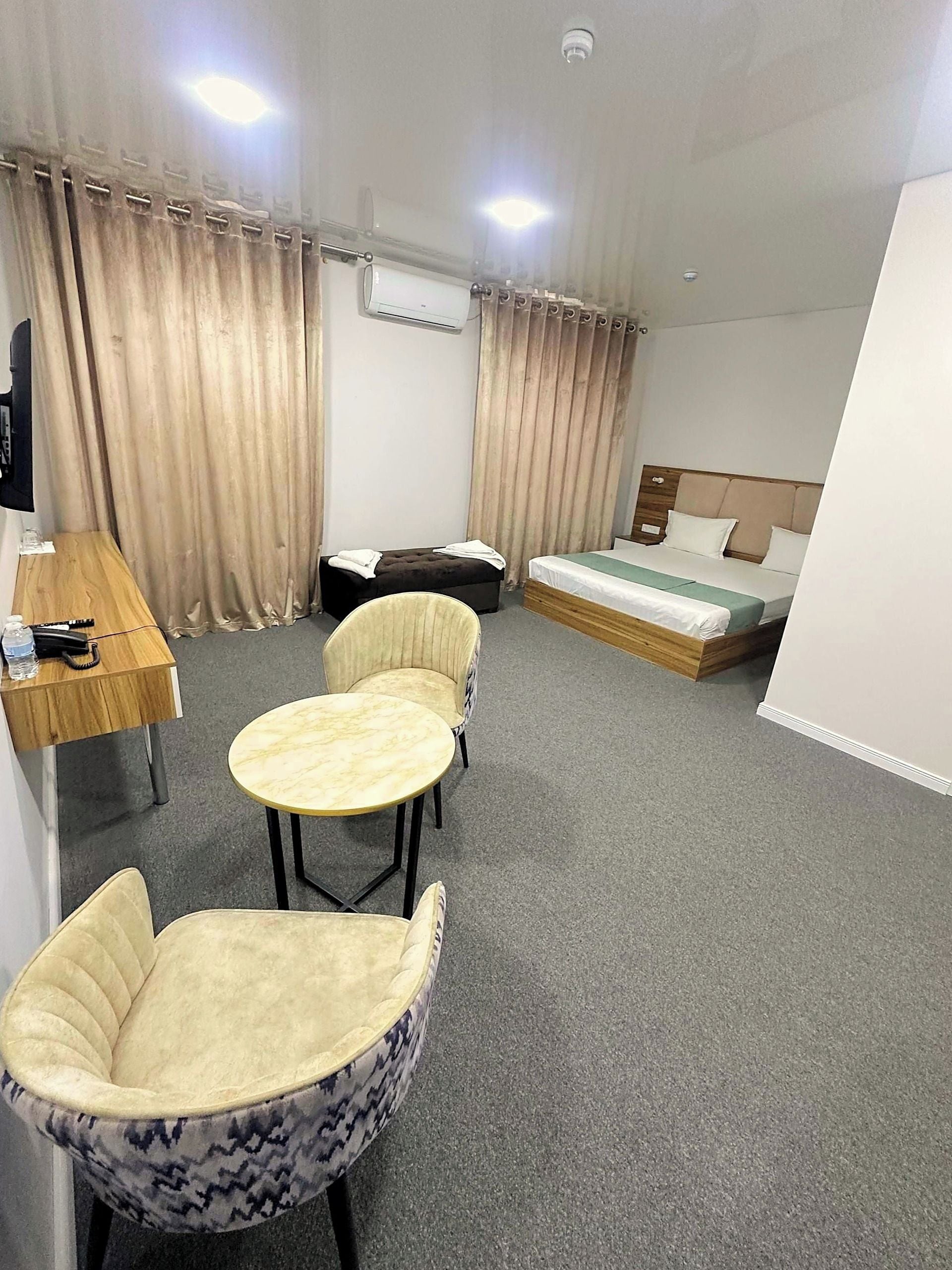 Een hotelkamer met een bed, een bureau, een stoel en een bank.