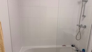 A bathroom with a glass-enclosed bathtub, a showerhead, and a handheld shower attachment. - Manchester 1-bed Apartment, Sleeps 2 (Manchester)