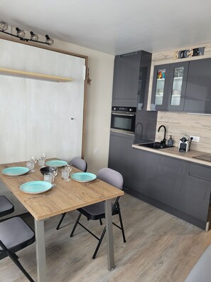 Eine moderne Küche mit grauen Schränken, einer Holz Arbeitsplatte und einem eingebauten Backofen.
