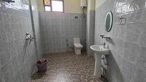 Un baño con inodoro, lavamanos y ducha.