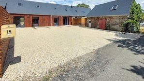 A building with a gravel driveway, wooden fencing, and a mailbox with the number 15. - Gorgeous home in Huisnes sur mer with WiFi (Huisnes sur mer)