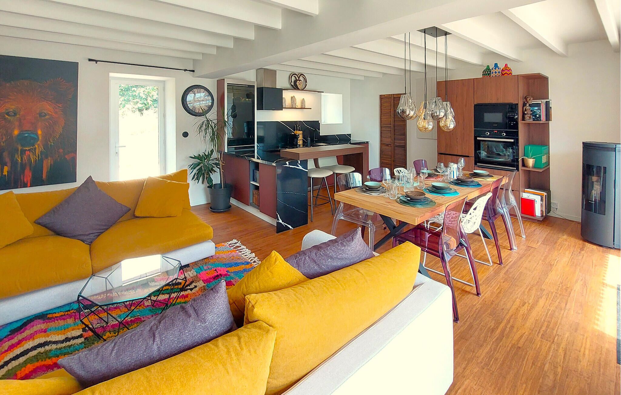 A modern living room with a sofa and a dining area with a table set for four.