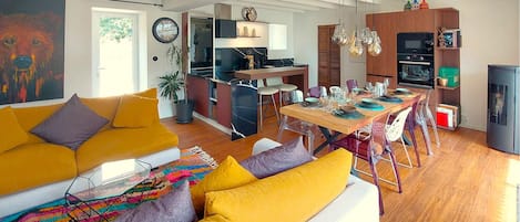 A modern living room with a sofa and a dining area with a table set for four.