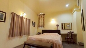 Un dormitorio con cama, un banco, un escritorio y una silla.
