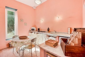 A kitchen with a table, chairs, a window, and a counter with various items. - [ilCeppo] 5Terre-Seaview-Parking (La Spezia)