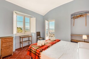 A bedroom with a bed, a desk, a chair, and a window with an open shutter. - [ilCeppo] 5Terre-Seaview-Parking (La Spezia)