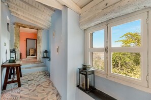 A room with a patterned floor, a wooden table, a window with a view, and a door leading to another room. - [ilCeppo] 5Terre-Seaview-Parking (La Spezia)
