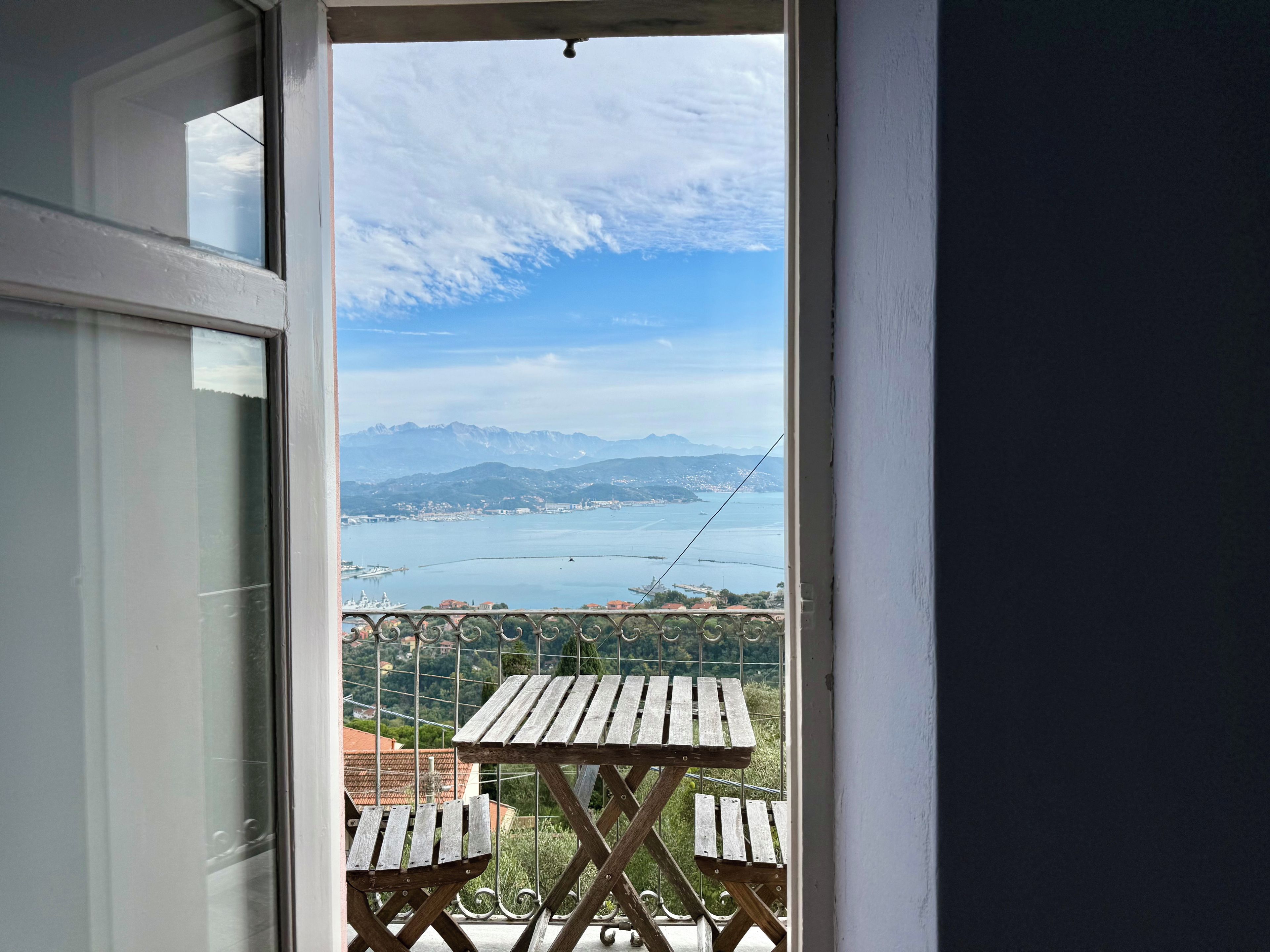 Un balcon avec vue sur une étendue d’eau et des montagnes.