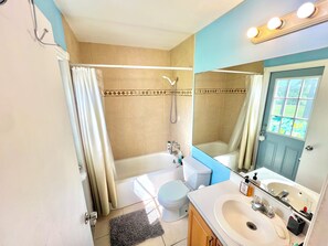 Un baño con bañera, inodoro y lavamanos.