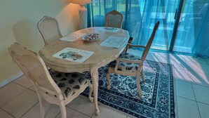 Ein Essbereich mit einem runden Tisch, vier Stühlen, einer Lampe und Blick durch eine Glastür.