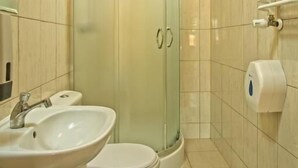 A bathroom with a glass shower enclosure, a sink, a toilet, and a towel rack.