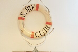 Ein runder Gegenstand mit der Aufschrift 'SURF CLUB', der an einer Wand hängt.