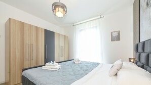 Ein modernes Schlafzimmer mit Bett, Kleiderschrank und Nachttisch.