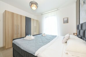 Ein modernes Schlafzimmer mit Bett, Kleiderschrank und Nachttisch.