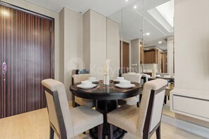 Un espace repas moderne avec une table ronde, quatre chaises et un vase central.