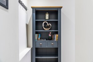 A dark grey bookshelf with a wooden top shelf, a decorative heart-shaped object, and several books. - Modern Flat In Jewellery Quarter, Free Parking (Birmingham)
