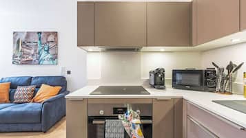 A modern kitchen with a built-in oven, microwave, and coffee maker.