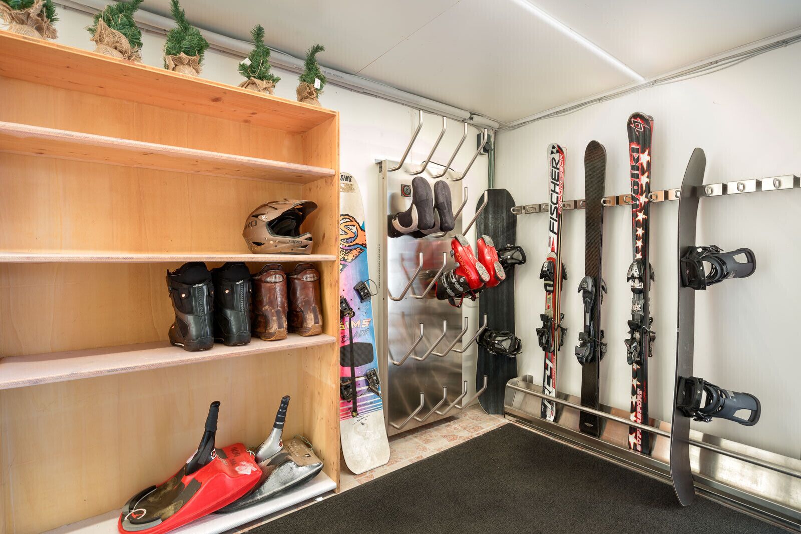 A ski storage area with shelves, skis, and ski boots.