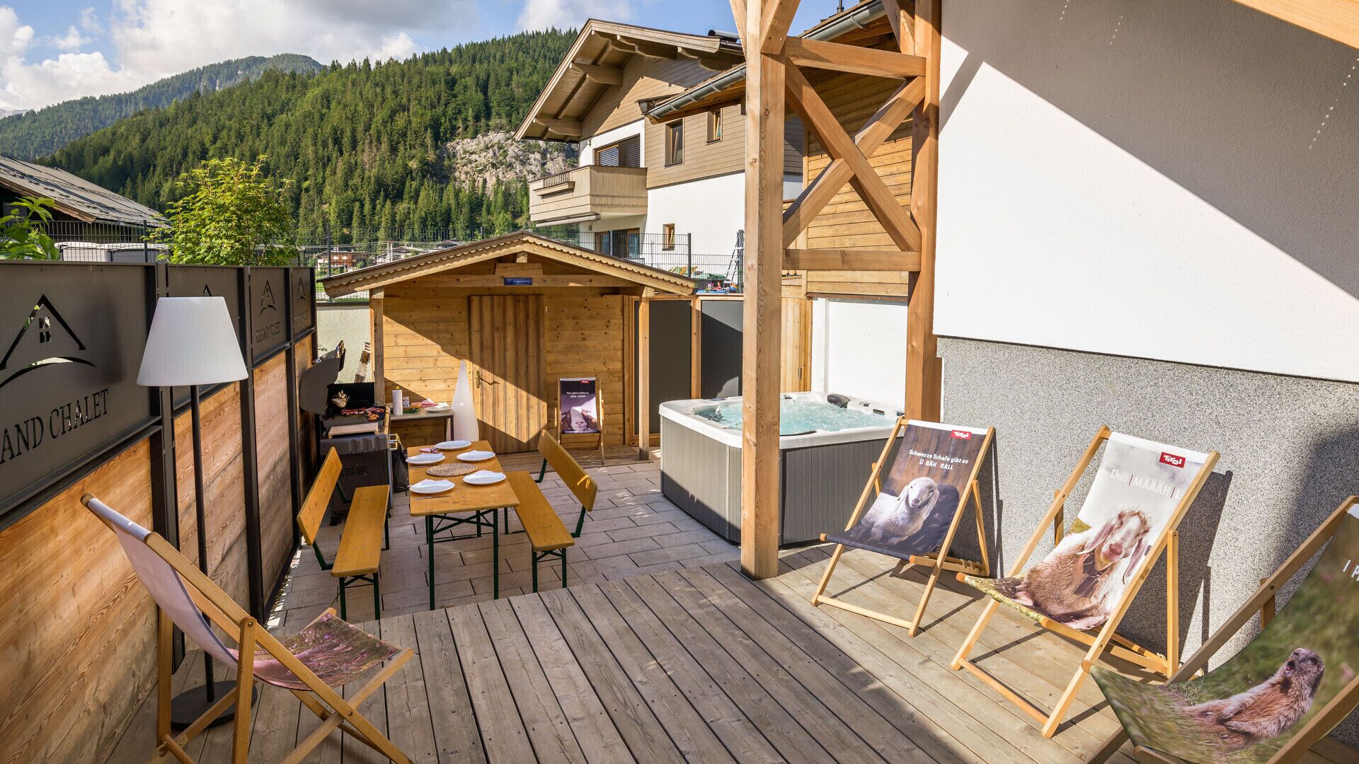 Een houten terras met een jacuzzi, zitplaatsen buiten en een bord met daarop een restaurant.