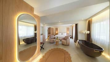 Una habitación de hotel moderna con un espejo grande, una bañera, un sofá, una mesita de café y una cama.