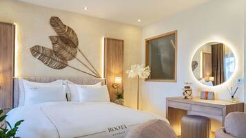 A hotel room with a bed, a bedside table, a mirror, and a wall-mounted artwork.