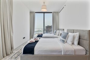 A hotel room with a large bed, a view of the cityscape, and a modern chandelier. - 3BR Apartment Partial Burj & Dubai Frame Panorama (Dubai)
