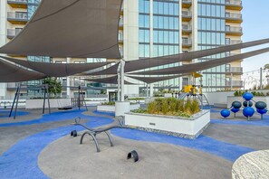 An outdoor playground with swings, a climbing structure, and a sandbox area. - 3BR Apartment Partial Burj & Dubai Frame Panorama (Dubai)