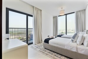 A modern hotel room with a large bed, a desk, and a balcony with a city view. - 3BR Apartment Partial Burj & Dubai Frame Panorama (Dubai)