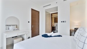 Ein Hotelzimmer mit Bett, Schreibtisch, Spiegel und Kleiderschrank.