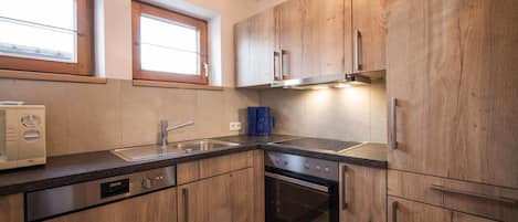 A kitchen with wooden cabinets, a built-in oven, and a dishwasher.
