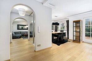 A modern interior with a dining area, a black leather sofa, and a glass cabinet. - Kitz-Heart Premium Top 2 (Kitzbühel)