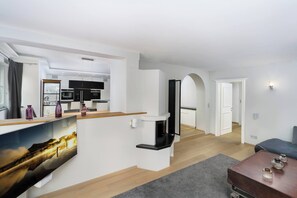 Un interior modern amb cuina, zona de dinar i espai de saló.