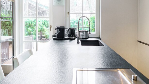 A kitchen with a large island, a sink, a toaster, and a coffee maker. - Kitz-Heart Premium Top 2 (Kitzbühel)