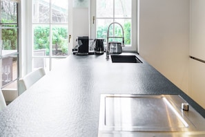 A kitchen with a large island, a sink, a toaster, and a coffee maker. - Kitz-Heart Premium Top 2 (Kitzbühel)