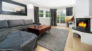 A modern living room with a sofa, coffee table, and fireplace. - Kitz-Heart Premium Top 2 (Kitzbühel)