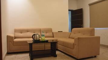 A living room with a beige sofa, a coffee table, and a bookshelf.