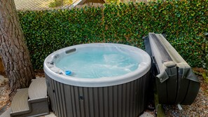 A hot tub with a cover, a step, and a chair. - Wildcat Lodge - couples retreat for two with a hot tub (Boat of Garten)