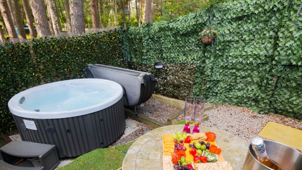 Un jacuzzi, asientos al aire libre y una bandeja de frutas sobre una mesa.