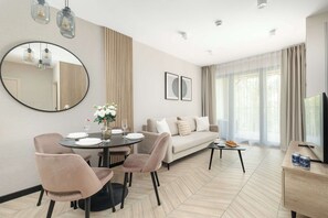 Ein modernes Wohnzimmer mit Essbereich, einer Couch, einem Couchtisch und einem Fernseher.