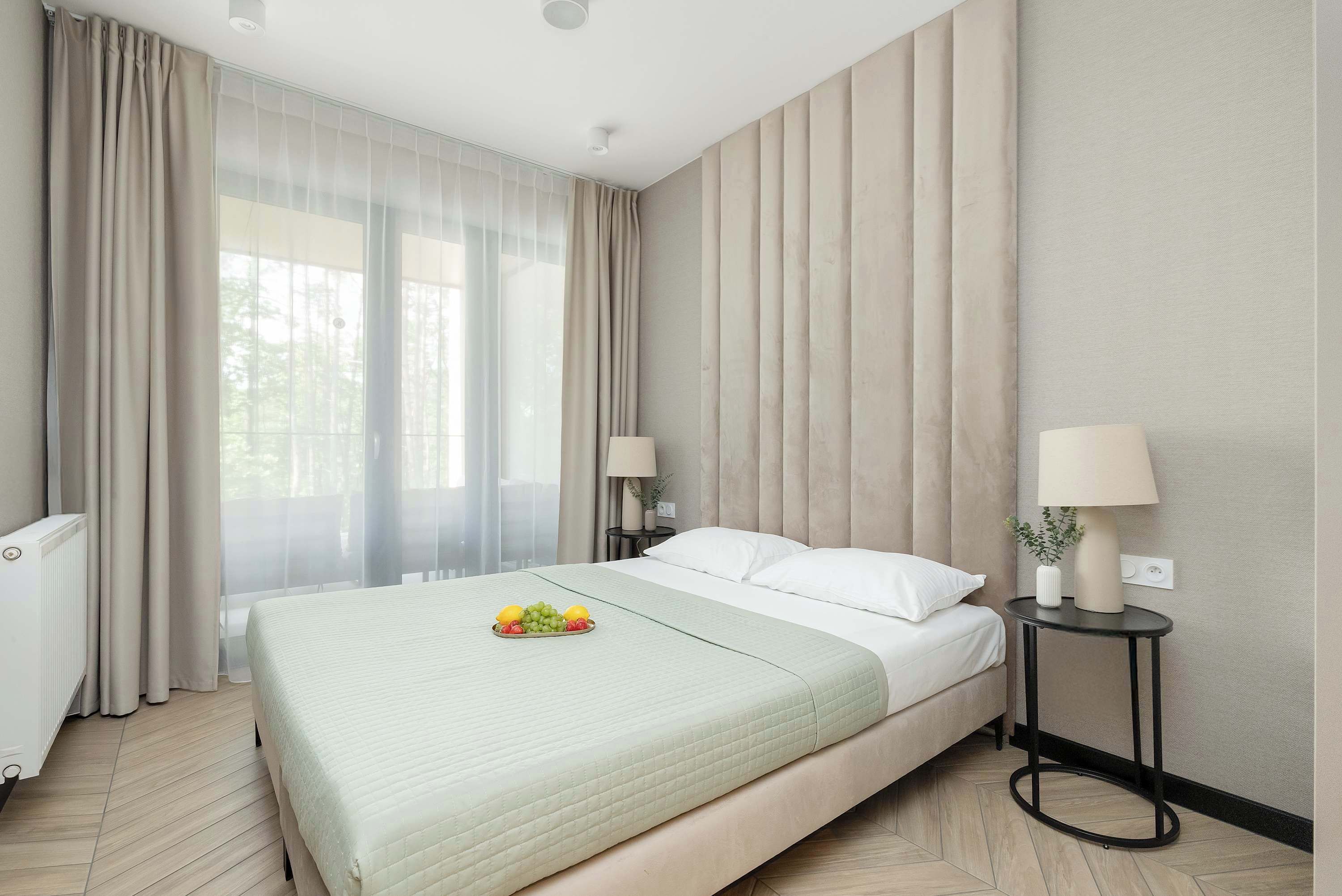 Ein Hotelzimmer mit Bett, Nachttisch, Lampe und Heizkörper.