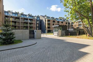 A modern residential building with multiple balconies and a paved entrance area. - Stylish Apartment with Access to the Gym and Spa Zone (Międzyzdroje)
