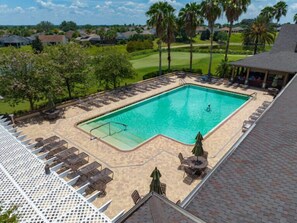 A rectangular swimming pool with a surrounding deck, lounge chairs, and umbrellas. - Hemingway Bloom - 3/2 w/ Grill in The Villages - Hemmingway (Hemmingway, The Villages)