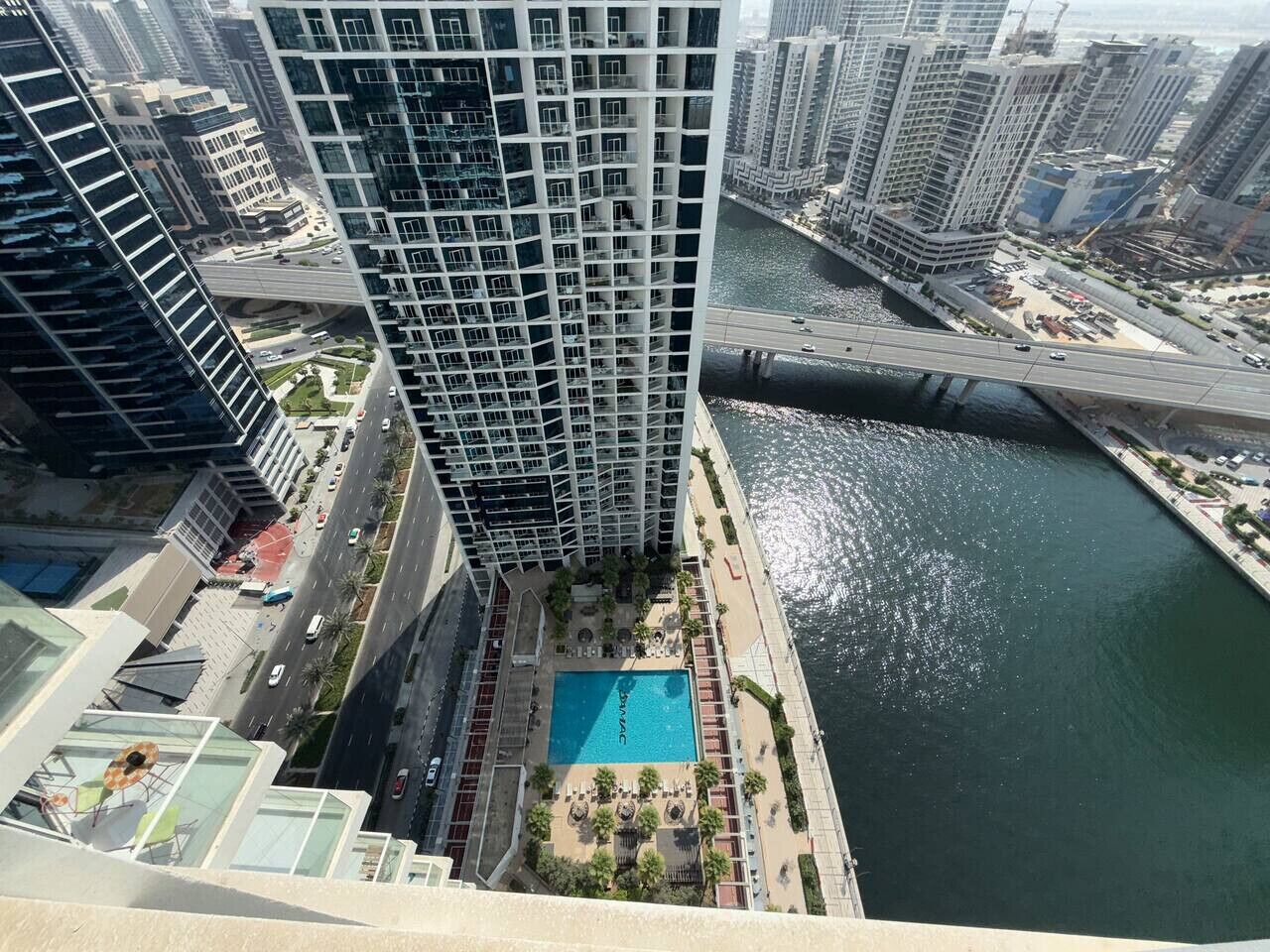 Un edificio de gran altura con piscina en la azotea y vistas al río.