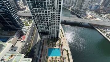 Un edificio de gran altura con piscina en la azotea y vistas al río.