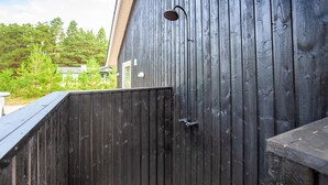 A wooden fence with a metal gate and a wall-mounted light fixture. - Beautiful home in Blåvand with sauna (Blåvand)