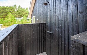 A wooden fence with a metal gate and a wall-mounted light fixture. - Beautiful home in Blåvand with sauna (Blåvand)