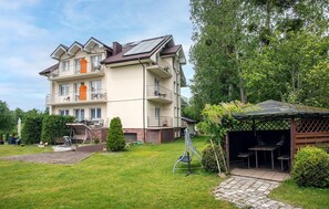 A multi-story residential building with balconies, a garden, and a gazebo. - Cozy apartment in Jastrzebia Gora with sauna (Jastrzebia Gora)