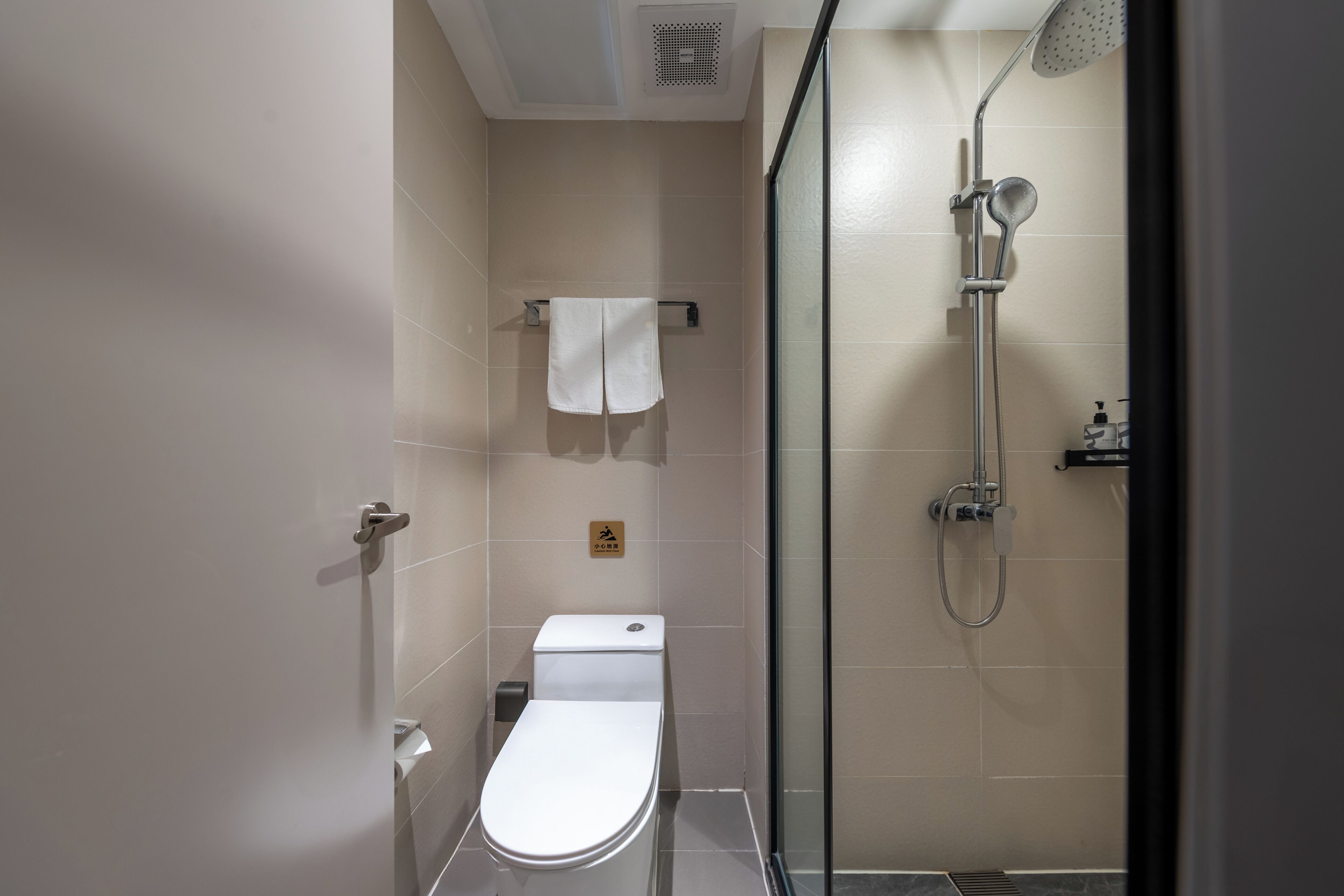 Un baño moderno con inodoro, ducha y mampara de vidrio.