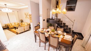 A dining area with a wooden table set for four, surrounded by chairs with cushioned seats. - Vista Palms Retreat 3 bed and 2 bath Private Hilltop house in Bunamwaya Kampala. (Kampala)